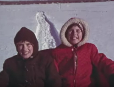 deux enfants souriants font de la luge